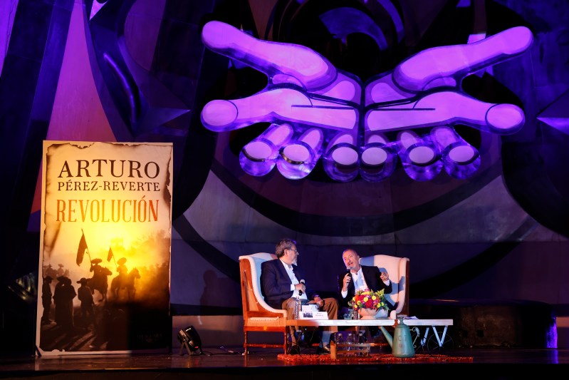 El escritor español Arturo Pérez-Reverte acompañado por el novelista mexicano Elmer Mendoza durante la presentación de su nuevo libro 'Revolución' en el Polyforum Siqueiros de Ciudad de México. Foto de EFE