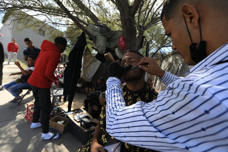 los barberos, que se han instaldo a escasos metros de la linea divisoria de México y Estados Unidos. Foto de EFE