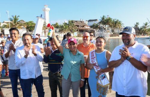 Blanca Merari Tziu da disparo de salida a embarcaciones del torneo de pesca en el marco del Torneo de Pesca en el marco del Festival del Día de la Marina en Puerto Morelos